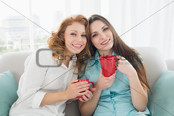 Female friends with coffee cups in the living room