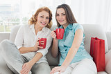 Female friends with coffee cups at home