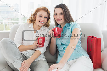Female friends with coffee cups at home