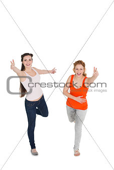 Cheerful young female friends with hand gestures