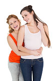 Cheerful female embracing her friend from behind