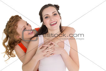 Young female embracing her cheerful friend from behind