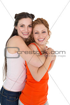 Side view portrait of a young female embracing her friend