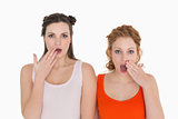 Shocked female friends with hand over mouth