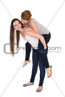 Full length of a young female piggybacking friend