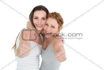 Portrait of two female friends gesturing thumbs up