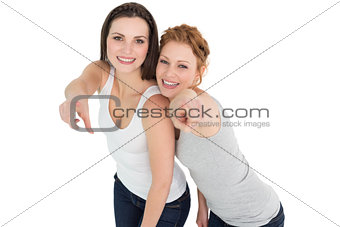 Female friends pointing against white background