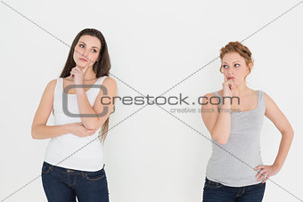 Two young thoughtful female friends standing