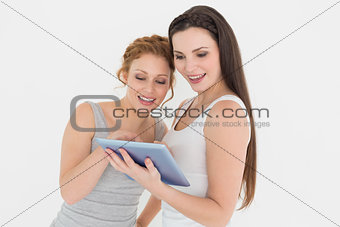 Two casual young female friends with digital tablet