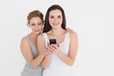 Two casual young female friends with mobile phone