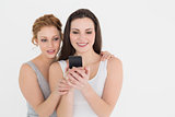 Casual young female friends looking at mobile phone