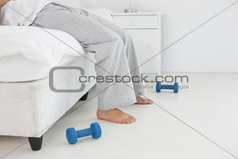 Low section of a man in pajama lying in bed