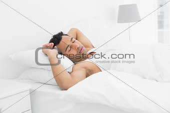 Side view of a man sleeping in bed