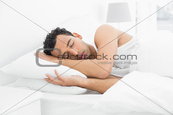 Side view of a man sleeping in bed