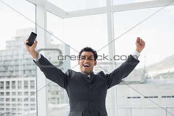 Elegant young businessman cheering in office