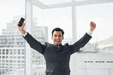 Cheerful elegant young businessman cheering in office