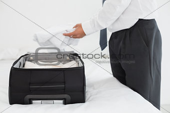 Businessman unpacking luggage at the hotel bedroom
