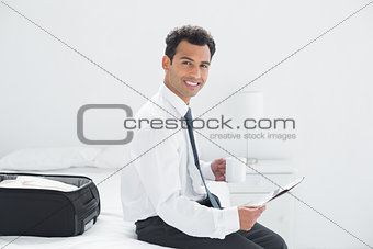 Businessman with cup reading newspaper at a hotel room