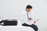 Businessman with cup reading newspaper at hotel room