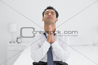 Serious young businessman with joined hands