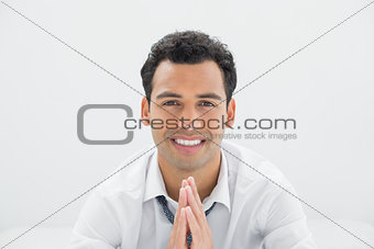 Smiling young businessman sitting on bed