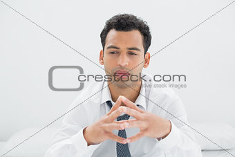 Close-up of a thoughtful businessman on bed