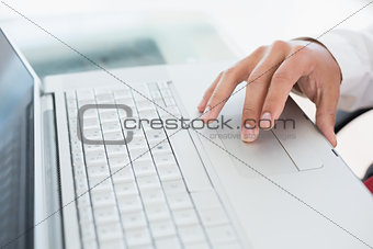 Hand using laptop at office desk