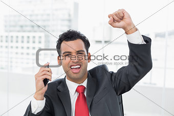 Businessman cheering with clenched fist at office