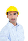 Portrait of a serious handyman wearing a yellow hard hat