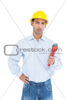 Handsome young handyman holding pipe wrench