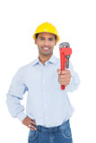 Portrait of a handsome young handyman holding pipe wrench