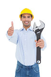 Handyman holding out a wrench while gesturing thumbs up