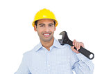 Portrait of a smiling young handyman holding a wrench