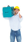 Handyman in hard hat with toolbox gesturing thumbs up