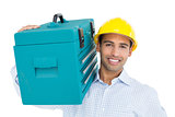 Portrait of a handyman in hard hat carrying a toolbox