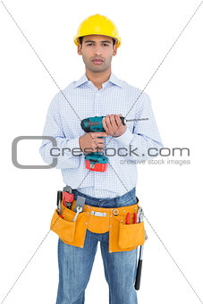 Serious handsome young handyman holding drill