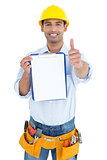 Handyman in yellow hard hat with clipboard gesturing thumbs up