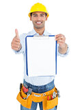 Handyman in yellow hard hat with clipboard gesturing thumbs up
