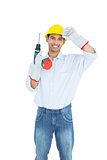 Smiling handsome young handyman in hard had with drill