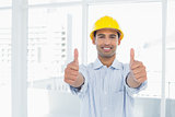 Handyman in yellow hard hat gesturing thumbs up in office