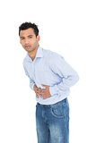 Portrait of a casual young man with stomach pain
