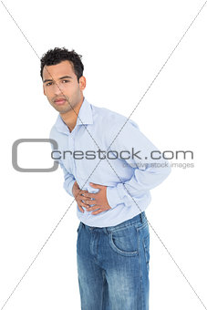 Portrait of a casual young man with stomach pain