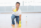 Man cleaning the floor while gesturing thumbs up at house