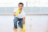 Smiling man cleaning the floor while gesturing okay sign
