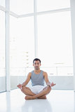 Full length of a young man sitting in lotus pose