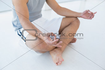 Close-up low section of a man sitting in lotus pose