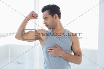 Fit young man flexing muscles in studio