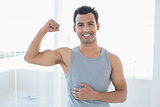 Portrait of a fit man flexing muscles in fitness studio