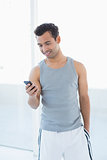 Young smiling man looking at mobile phone