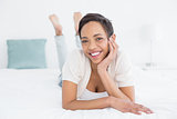 Smiling pretty young woman relaxing in bed